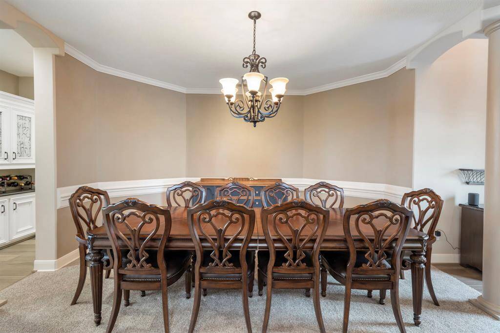 new dining oasis, where timeless elegance meets modern charm. Imagine hosting dinner parties under the warm glow of a classic chandelier, surrounded by exquisite woodwork and sophisticated wainscoting.