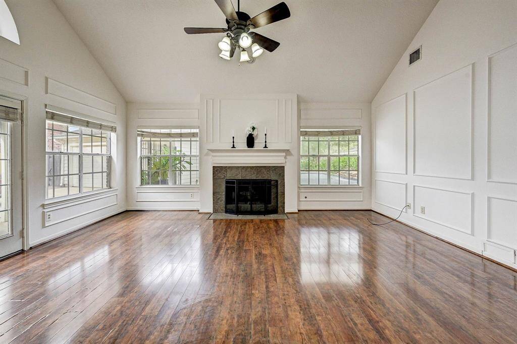 Living room with an inviting fireplace and walls of windows.
