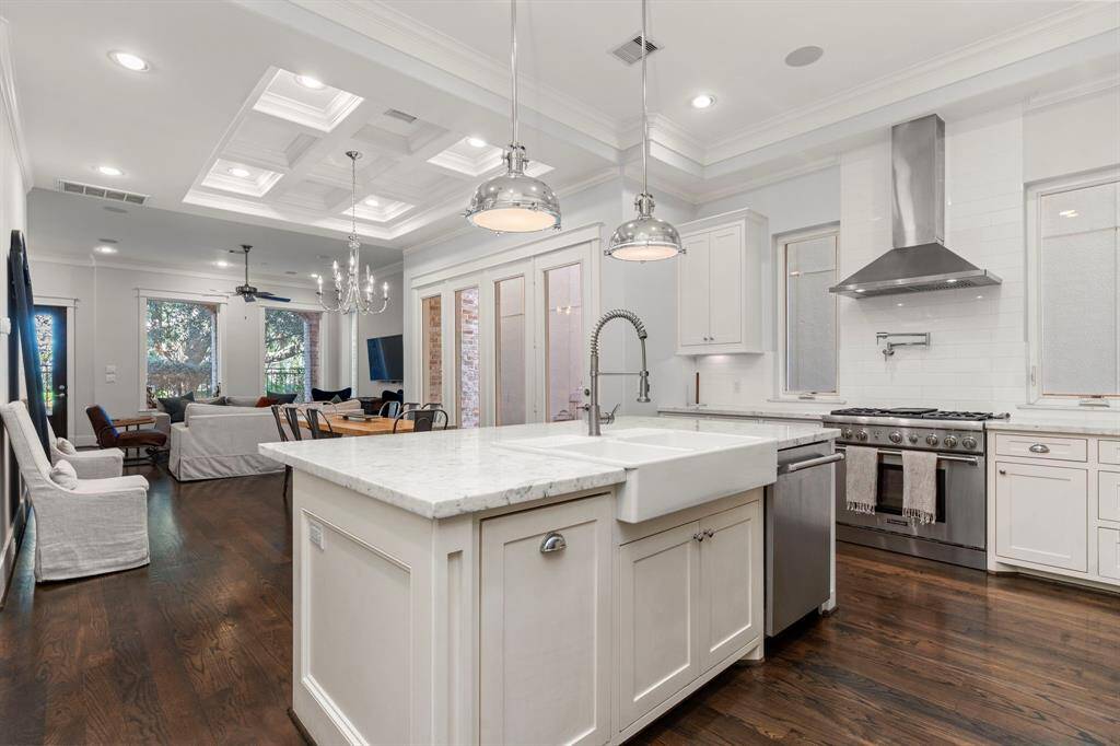 The home's open layout, high ceilings, and large windows create a bright, airy ambiance. The kitchen adds to the charm with chrome fixtures and elegant stone countertops.