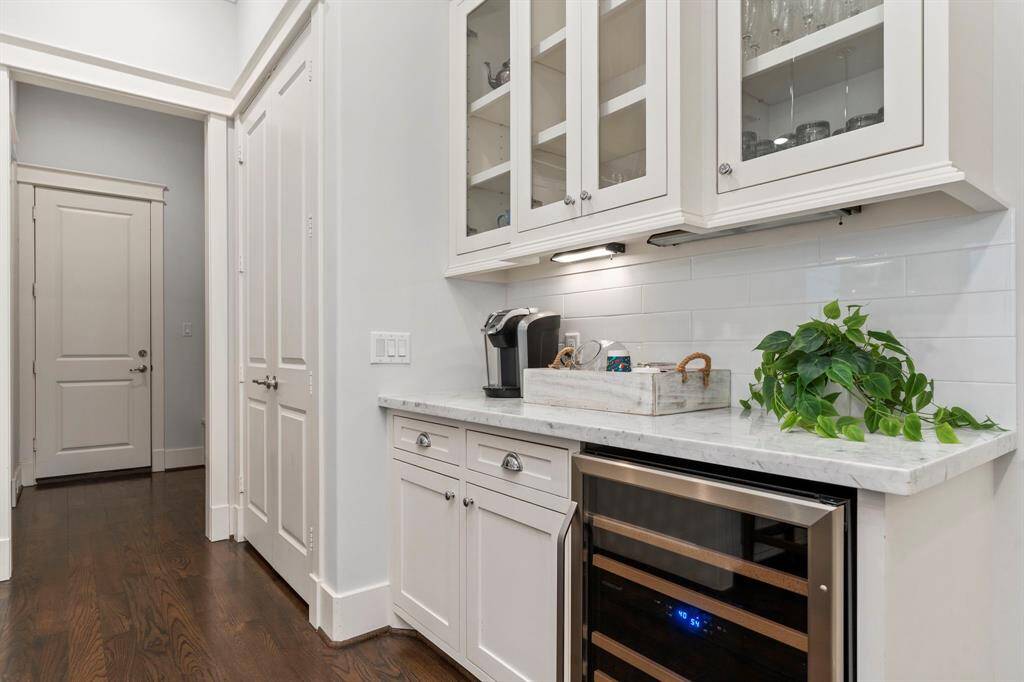 Enjoy both living and entertaining with the charming bar area adjacent to the kitchen, complete with elegant glass-front cabinets and a wine refrigerator.