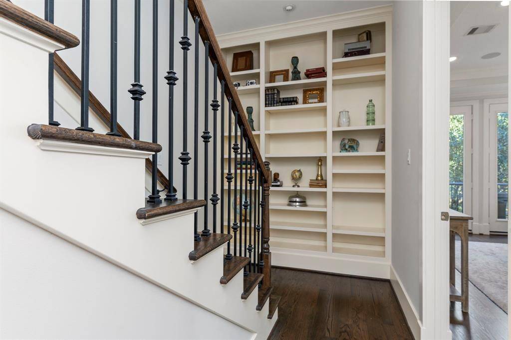 The built-in shelving by the stairs offers a perfect space to display your favorite collectibles and books.