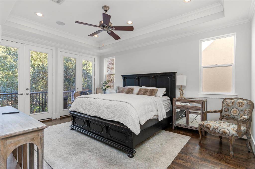 The primary suite is a serene retreat, featuring an elegant tray ceiling with recessed lighting and a ceiling fan, along with double glass doors that open to a private balcony. The treetop views are simply delightful!