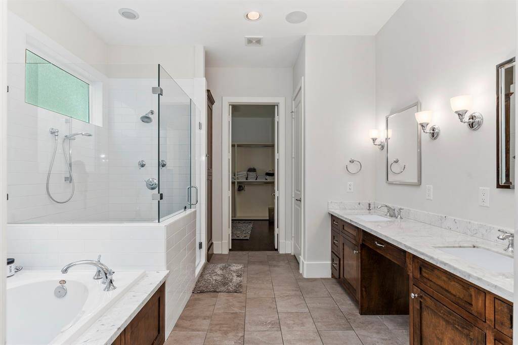 The primary suite is a tranquil escape, with this view leading into the beautifully designed bathroom. It also offers a spacious walk-in closet!