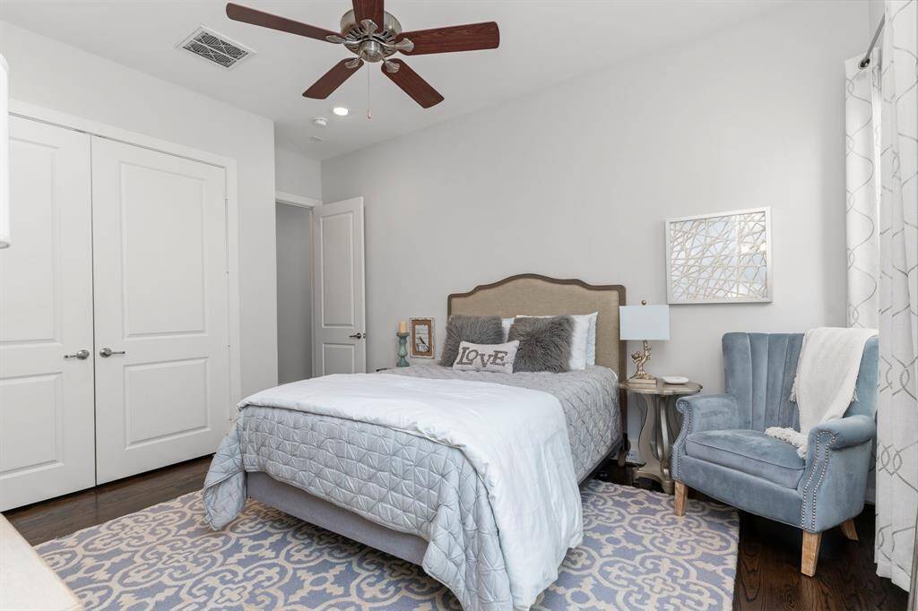 The second bedroom features hardwood flooring, recessed lighting, a ceiling fan, a private ensuite bathroom, and large windows.