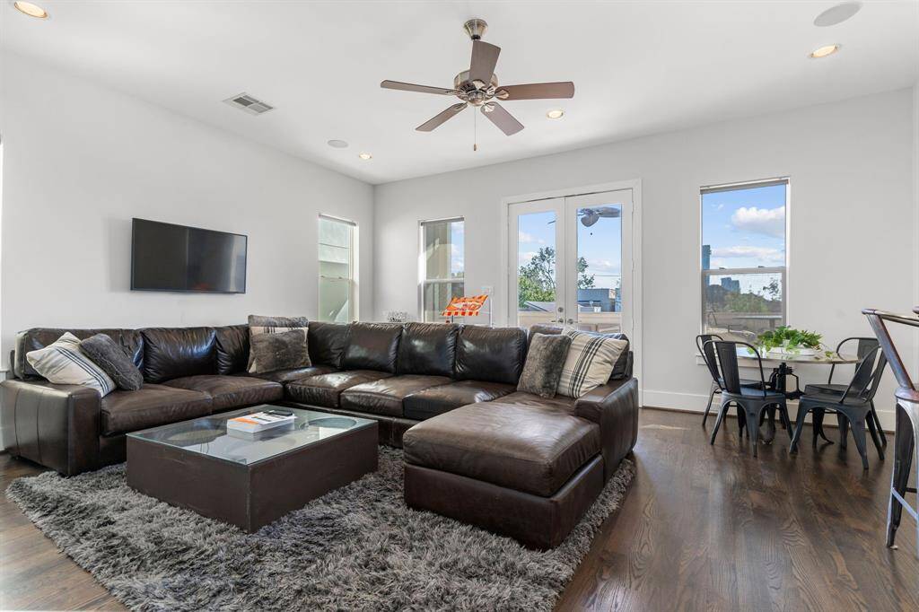 The fantastic third-floor game room is a versatile space with elegant wood flooring, recessed lighting, a ceiling fan, and direct access to a spacious rooftop balcony!