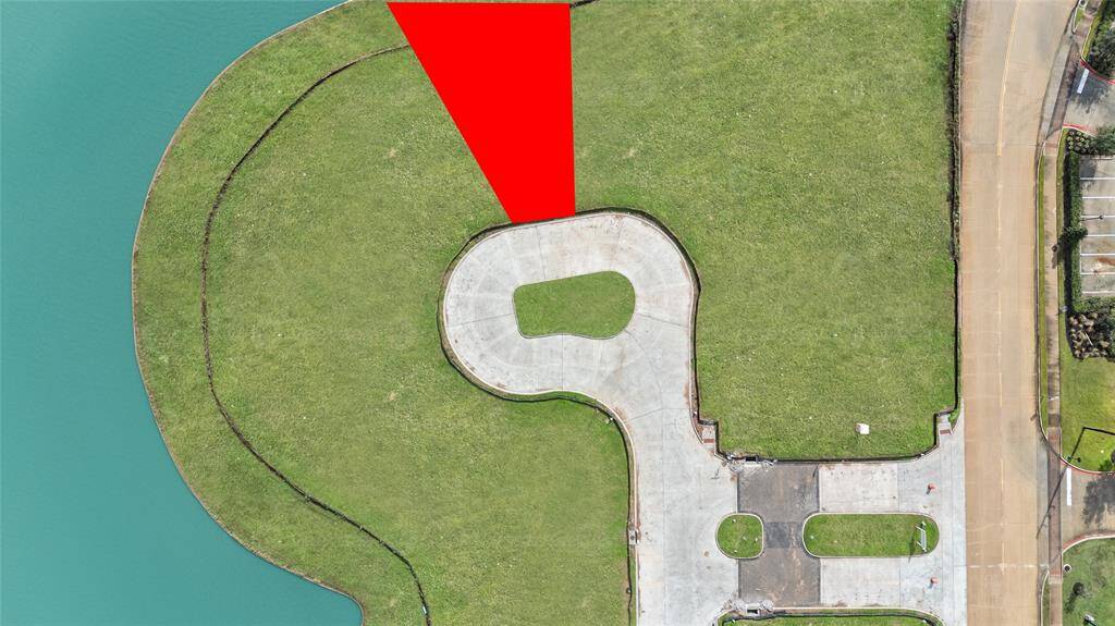 Enjoy this close-up aerial view of the picturesque waterfront lot, offering peaceful water views and ample space to create a one-of-a-kind home. Situated in the sought-after Monet Estates, this property is a rare gem in Sugar Land's master-planned Riverstone community.