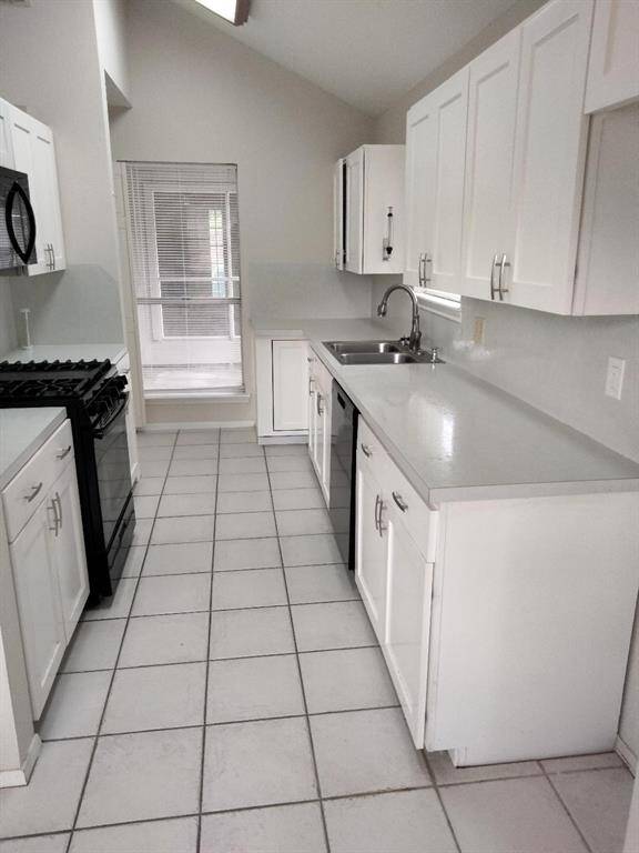 Pass thru kitchen features black appliances and access to dining area and also breakfast area.