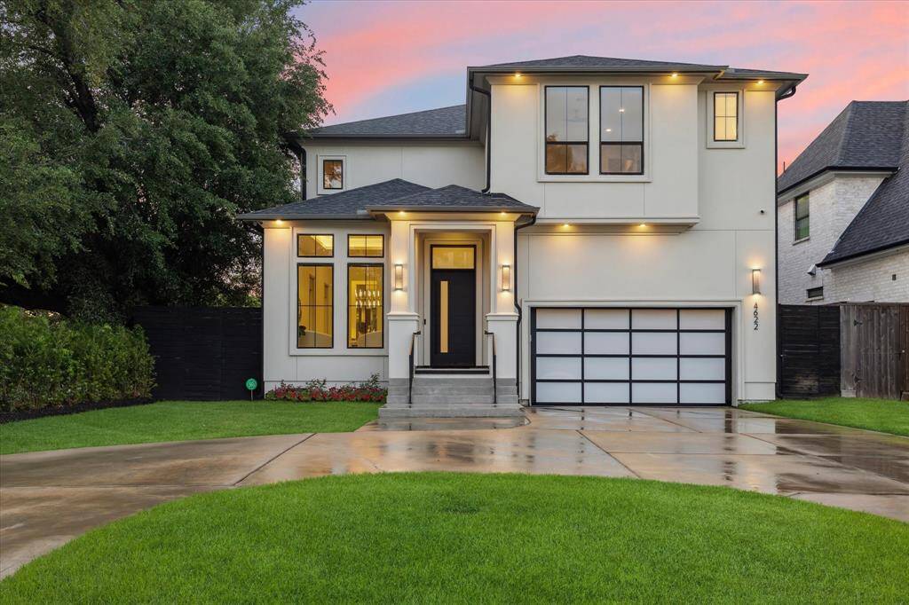 Sleek and sophisticated, this contemporary home stuns with clean lines, a mix of stucco and stone, and a striking frosted glass garage door. The circular driveway adds elegance and convenience, while large windows and modern landscaping complete the upscale curb appeal.