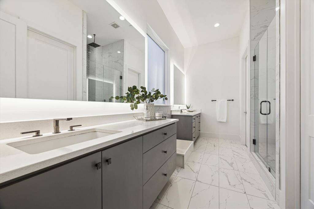 [GUEST EN-SUITE BATHROOM] The in-law suite’s en-suite bath is both stylish and functional, featuring dual vanities with sleek finishes and a spacious walk-in shower with contemporary tilework.
