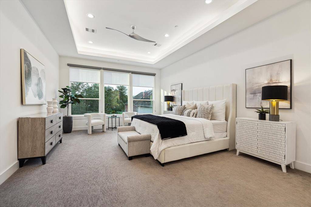 [PRIMARY BEDROOM] The primary bedroom is a true retreat, offering a spacious layout that seamlessly blends comfort and style. With a dedicated seating area for relaxation, large windows fill the room with natural light and offer tranquil views of the outdoors.