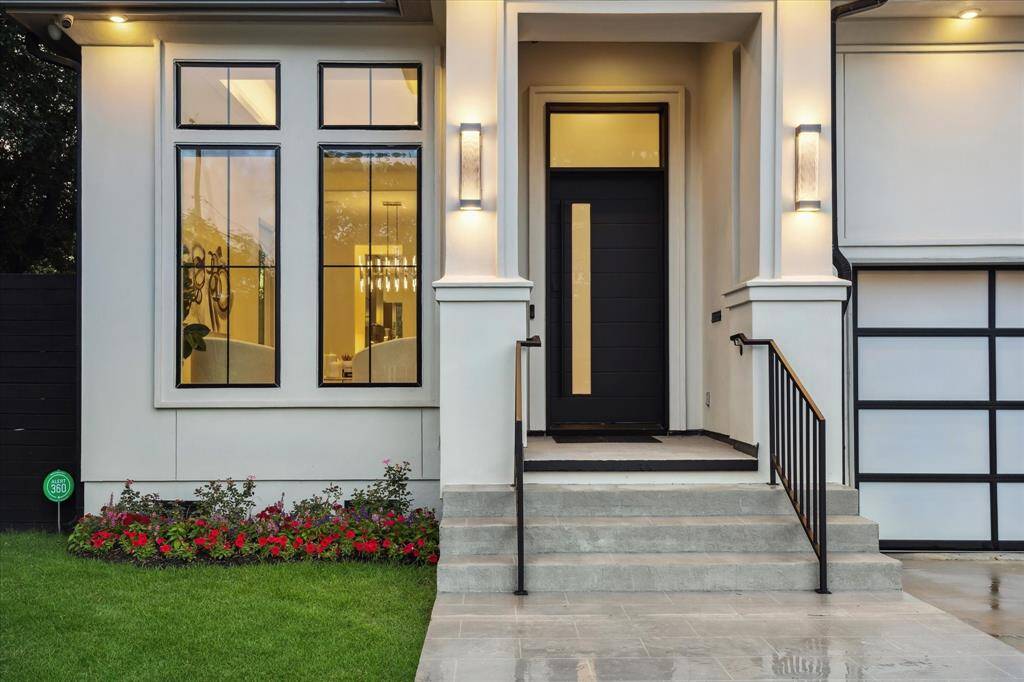 A statement front door completes the look, setting the tone for the luxury that awaits inside. Stunning glass windows glow day and night, showcasing the home’s modern elegance and warm interior ambiance.