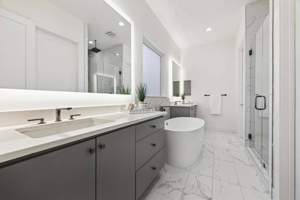 [PRIMARY BATHROOM] The luxurious primary bathroom offers a spa-like experience, featuring two separate vanities with expansive counter spaces for ultimate convenience. With contemporary finishes and thoughtful design, this bathroom combines both functionality and indulgence, creating the perfect space to unwind and refresh.