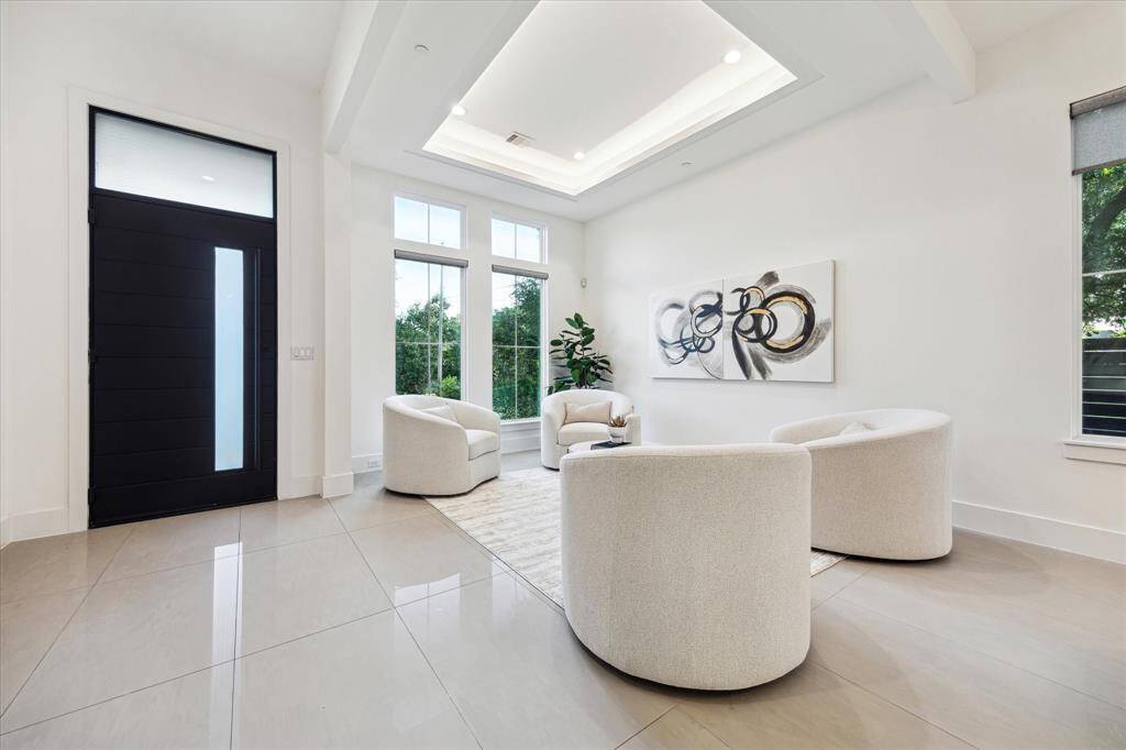 Welcome to refined elegance from the moment you arrive. The striking entryway sets the tone with soaring ceilings, clean architectural lines, and abundant natural light that flows effortlessly into the formal living room.