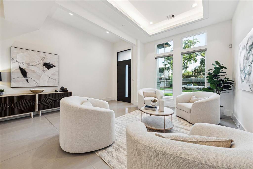 [LIVING ROOM] Designed for both grand entertaining and intimate gatherings, the space features oversized windows, sleek finishes, and a seamless connection to the home's modern aesthetic. Sophistication meets comfort in this thoughtfully curated setting—perfect for welcoming guests.