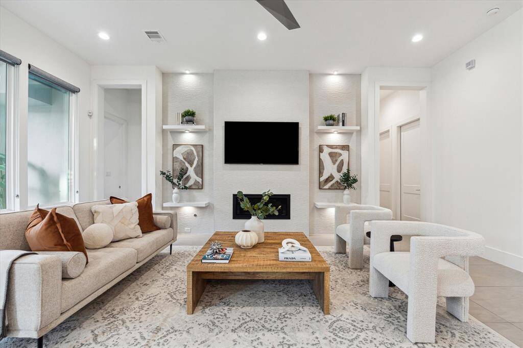 [FAMILY ROOM] A true centerpiece for everyday living and entertaining, the family room blends warmth and modern design with a sleek fireplace, integrated TV niche, and custom floating shelves that offer both function and flair.