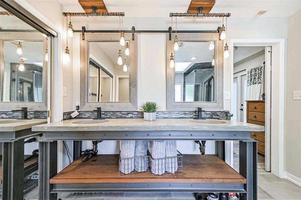 Double sinks with cement countertops & chic mirrors. Decorative lighting sets the perfect mood.