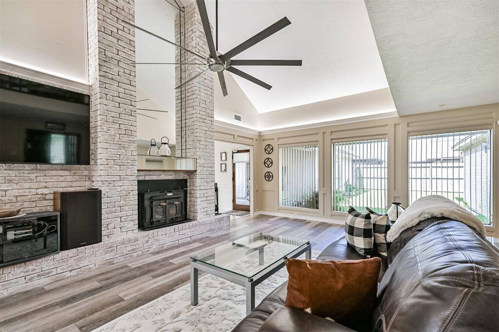 Soaring ceilings create an open, airy feel. Whitewashed brick accent wall adds charm and texture.
