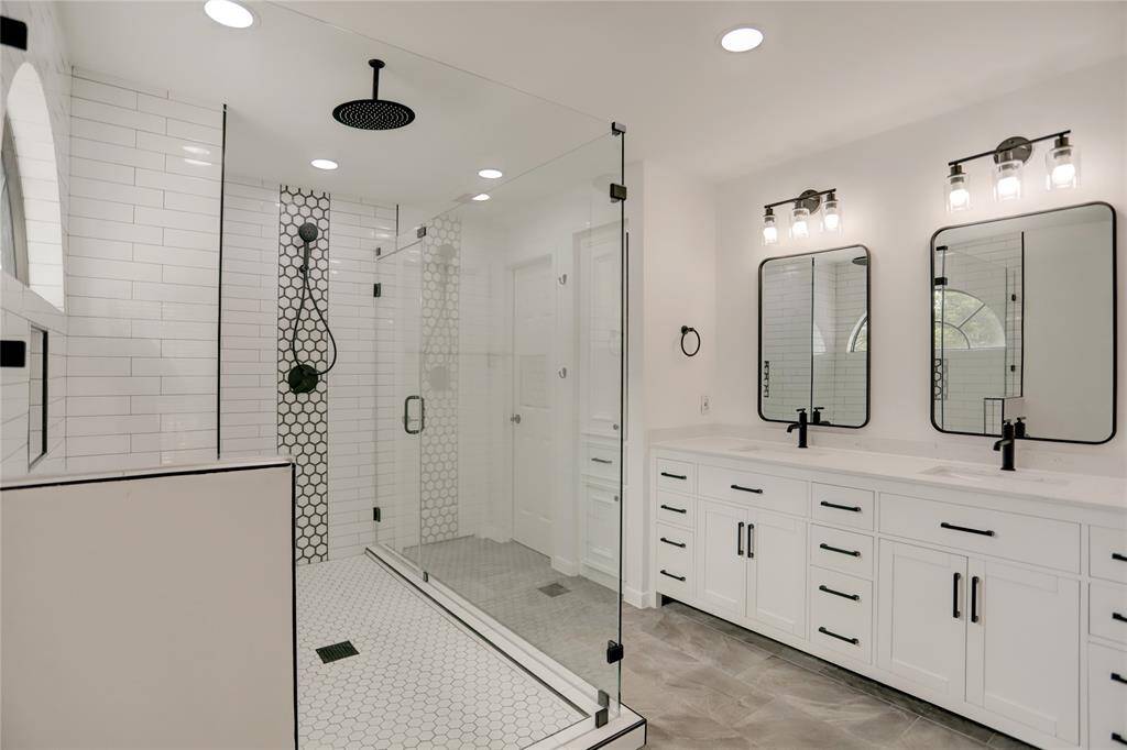 The Primary Bathroom is beautifully updated and features a double vanity, 2 walk-in closets and an oversized shower with bench and 2 shower heads.