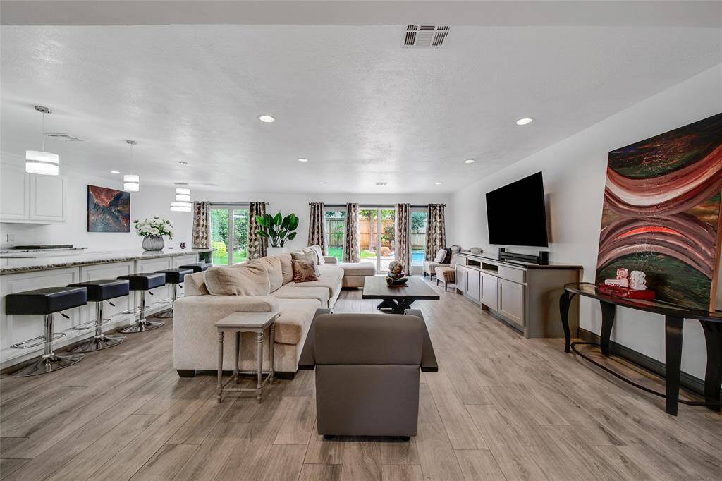 Open Floor plan of kitchen, living and breakfast area with custom cabinetry for entertainment area and storage.