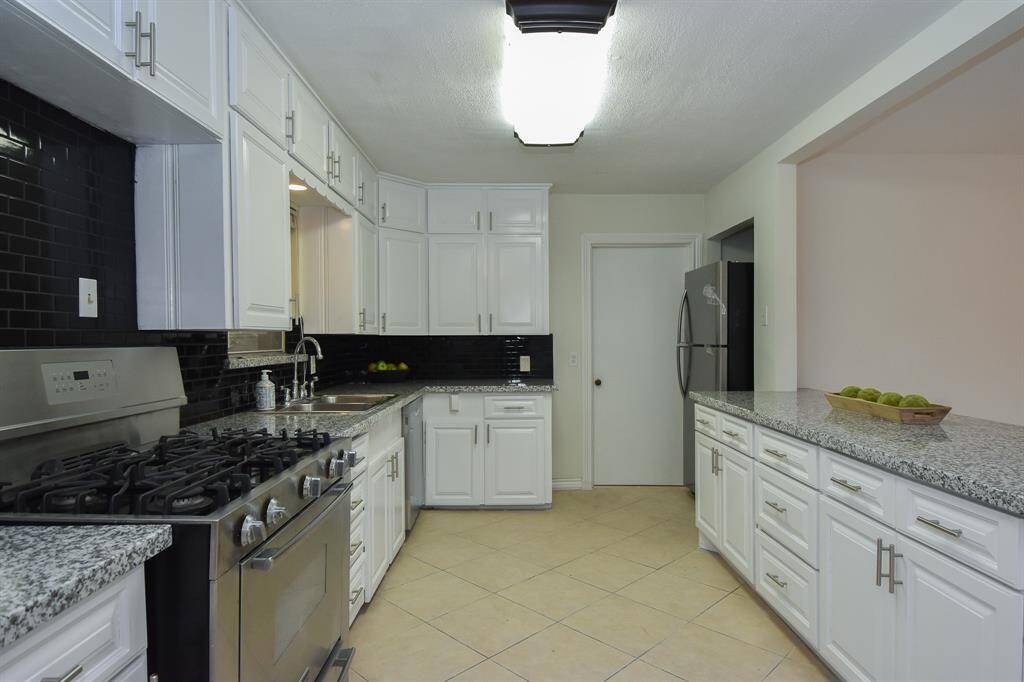 Large updated kitchen with five burner, gas stainless steel oven/range.  Stainless refrigerator and dishwasher.