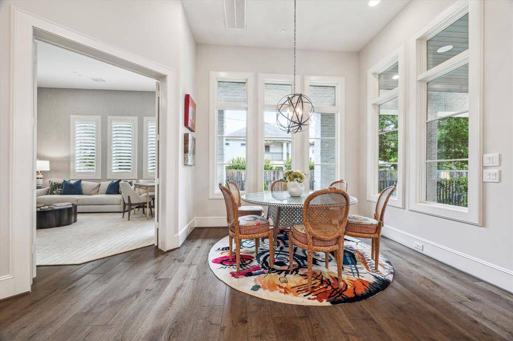 Flooded with natural light from a trio of tall windows, the breakfast room offers a cheerful and stylish setting for casual dining, framed by views of the outdoor living space. Its airy ambiance and effortless flow from the kitchen make it a charming everyday gathering spot.