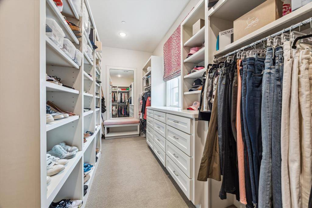 Primary closet reveals thoughtfully designed storage with abundant drawers, built-in shelving, and a cozy window bench framed by natural light—combining elegance with everyday function.