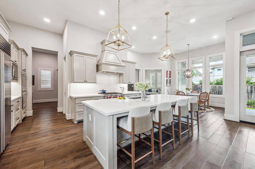 This chef-inspired kitchen impresses with sleek quartz countertops, custom cabinetry, and a spacious island illuminated by striking geometric pendant lights. Seamlessly connected to the dining and living areas, it’s designed for both everyday elegance and effortless entertaining.