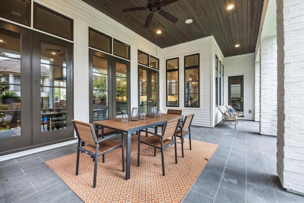 This expansive covered patio is a seamless extension of the home’s living space, featuring a wood-paneled ceiling, elegant tile flooring, and ample room for al fresco dining and lounging—perfect for year-round entertaining.
