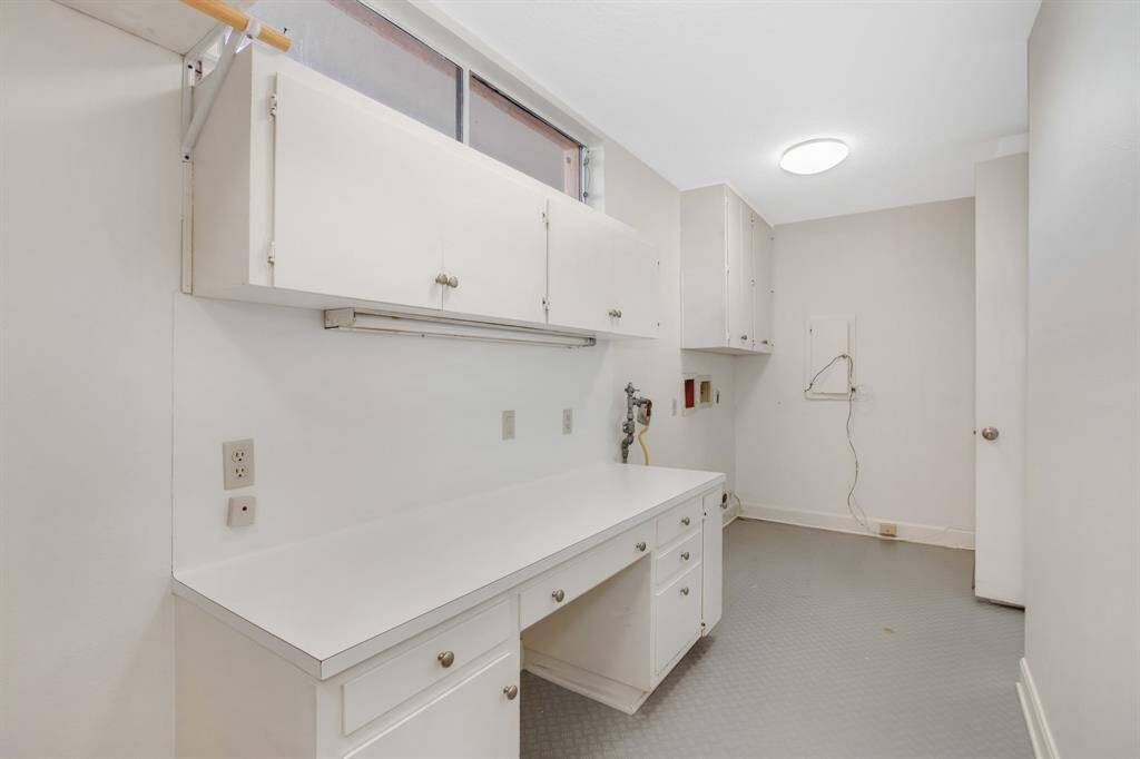 Utility room with built in shelving and connects the kitchen to the gym area.