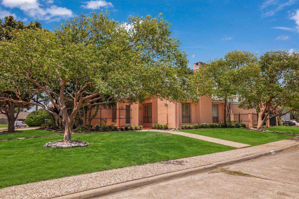 Beautiful Colony Park home featuring a peach-colored exterior with a tidy, landscaped front yard and mature shade trees. The house has a welcoming entrance with a covered porch area.