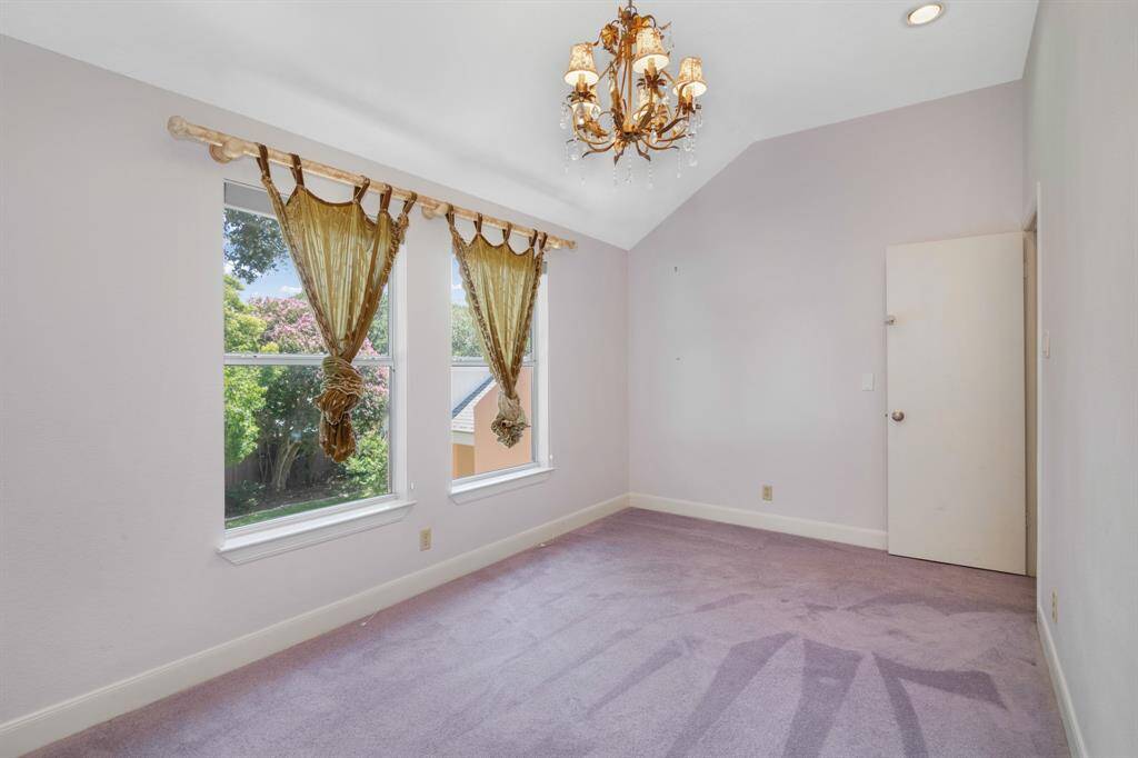 Bedroom #5:  It features a chandelier, soft carpeting, and a neutral color palette, offering a cozy and versatile space.