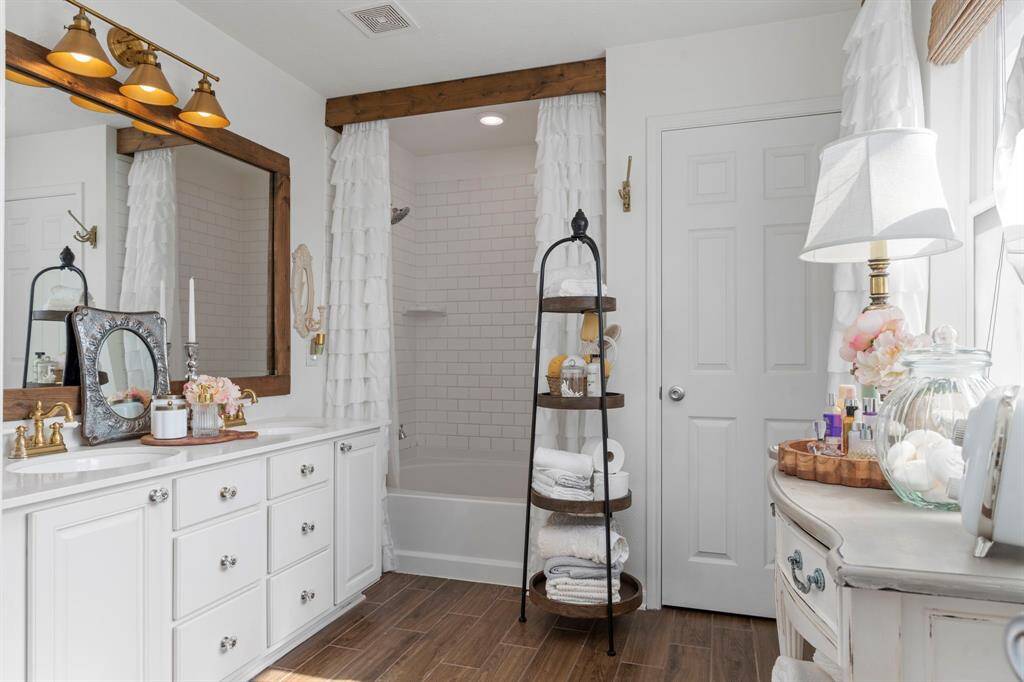Primary bathroom with dual vanity and a tub/shower combo