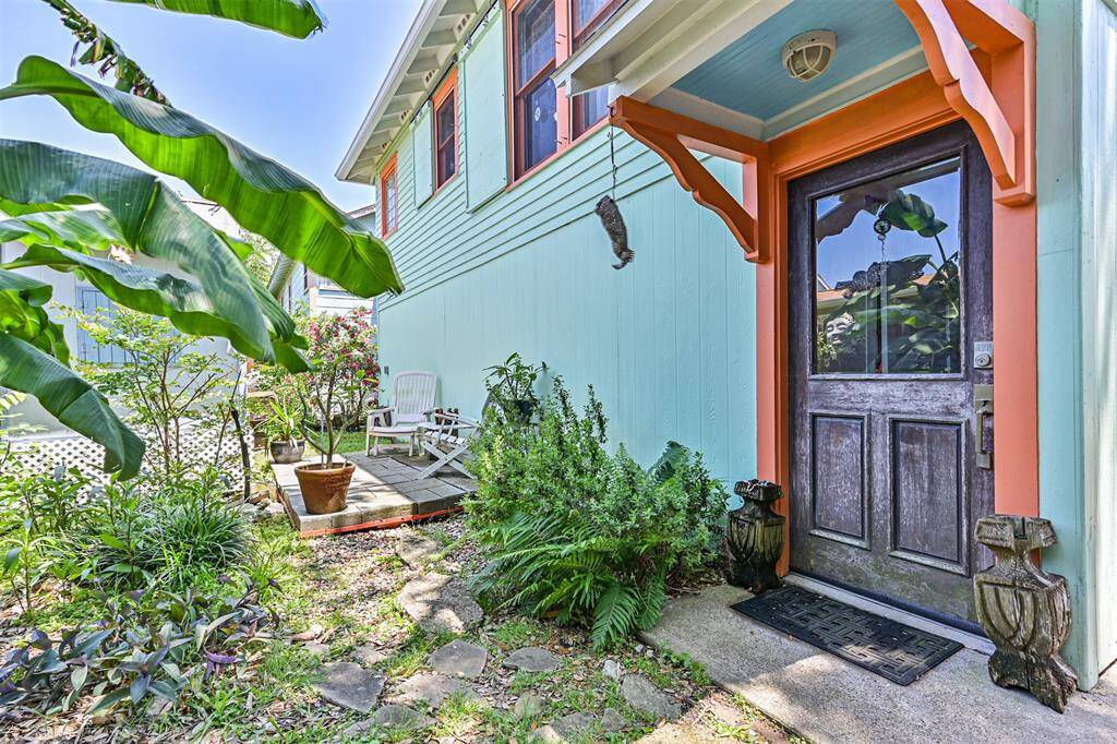 Another view of the driveway with lush greenery and potted plants, creating a cozy outdoor sitting area.