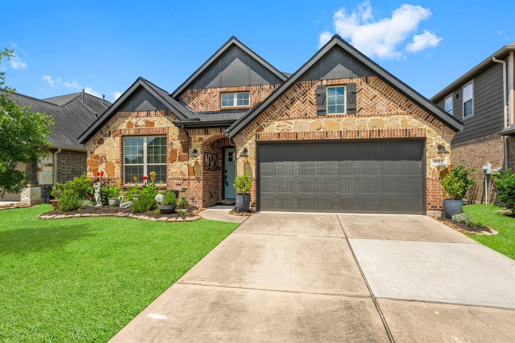 Experience stunning curb appeal with lush landscaping, a sprinkler system, elegant brick and stone facade, and a spacious double-wide driveway.