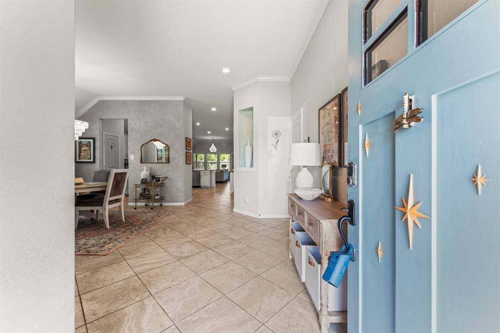 Step through the elegant custom-painted front door with gold accents, onto beautiful tile flooring.