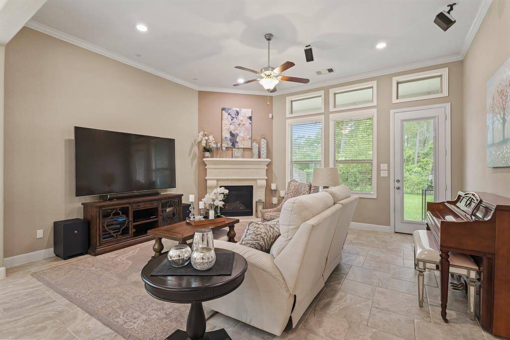 This stunning living room is spacious enough for the whole family, and features crown molding details, a gorgeous fireplace with mantle, and a view of the backyard through the large windows!