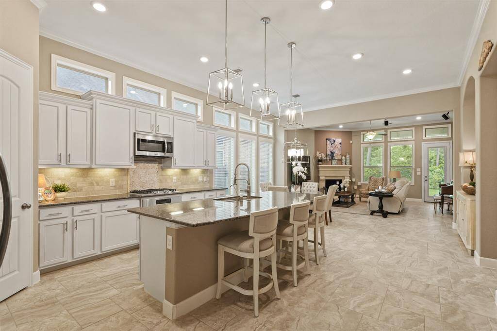 This open concept has great illumination thanks to large windows, pendant, and recessed lighting.