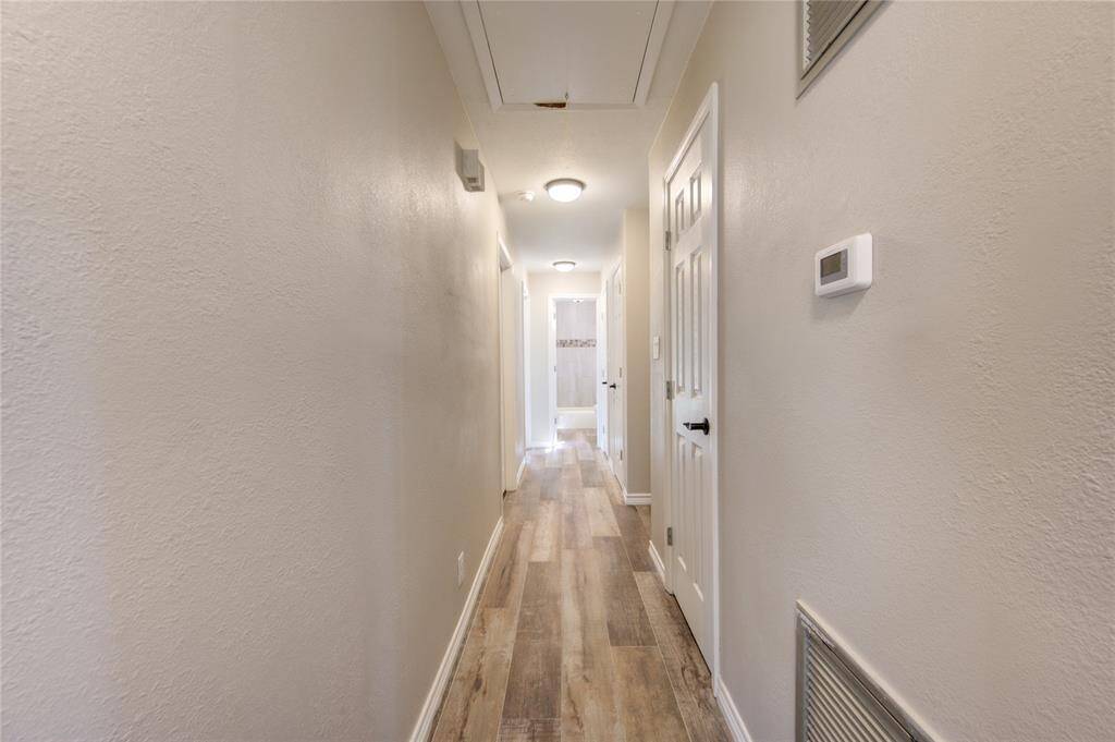 As you leave the primary bedroom and walk down this bright hall towards the guest bathroom you will pass 3 spacious closets on your right and two bright and airy secondary bedrooms. (Please note that the furniture stored in the middle bedroom will be removed next week.)