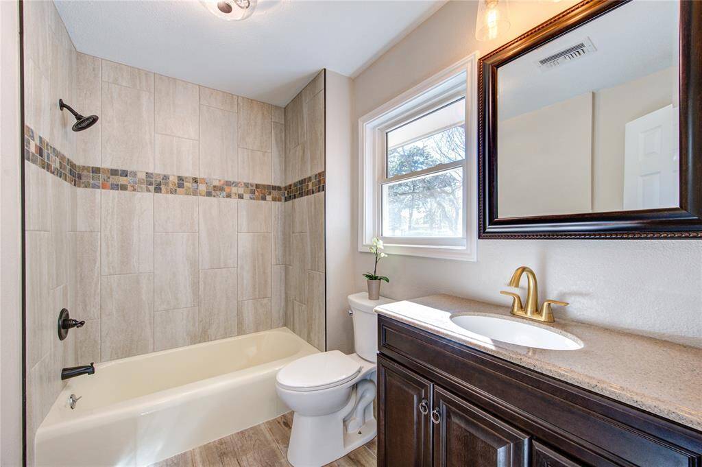 The secondary bathroom is also fully renovated with beautifully decorative tile and is also bright and airy. (The homeowner will be installing window treatments for privacy.)