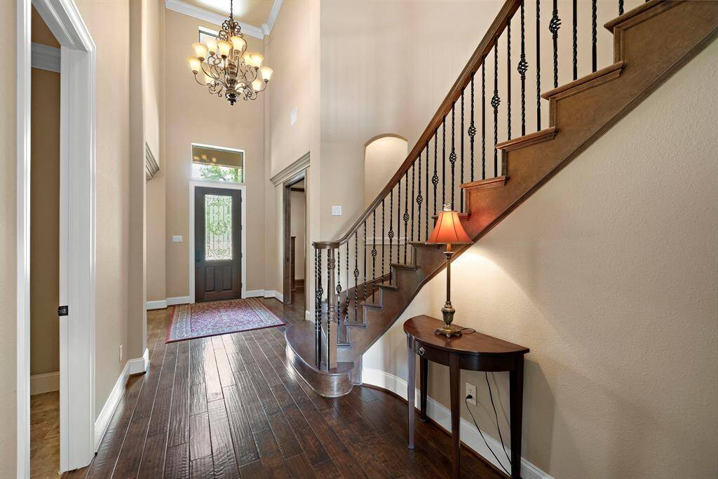 Natural light streams through the glass-paneled front door, enhancing the spacious feel.