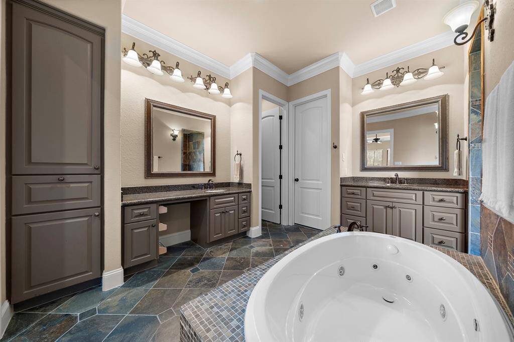 This charming home features a stone facade with a welcoming front entrance and beautifully landscaped front yard. It is situated in a serene, spacious setting with lush green lawns and mature trees, offering a peaceful and private atmosphere.