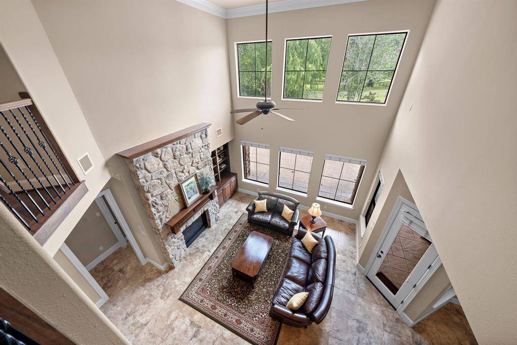 Elegant upstairs landing offering a stunning view of the spacious living area and large, sunlit windows.