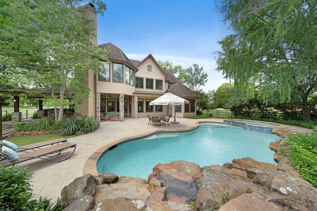 This outdoor retreat has been completely enclosed with elegant black wrought iron fencing.