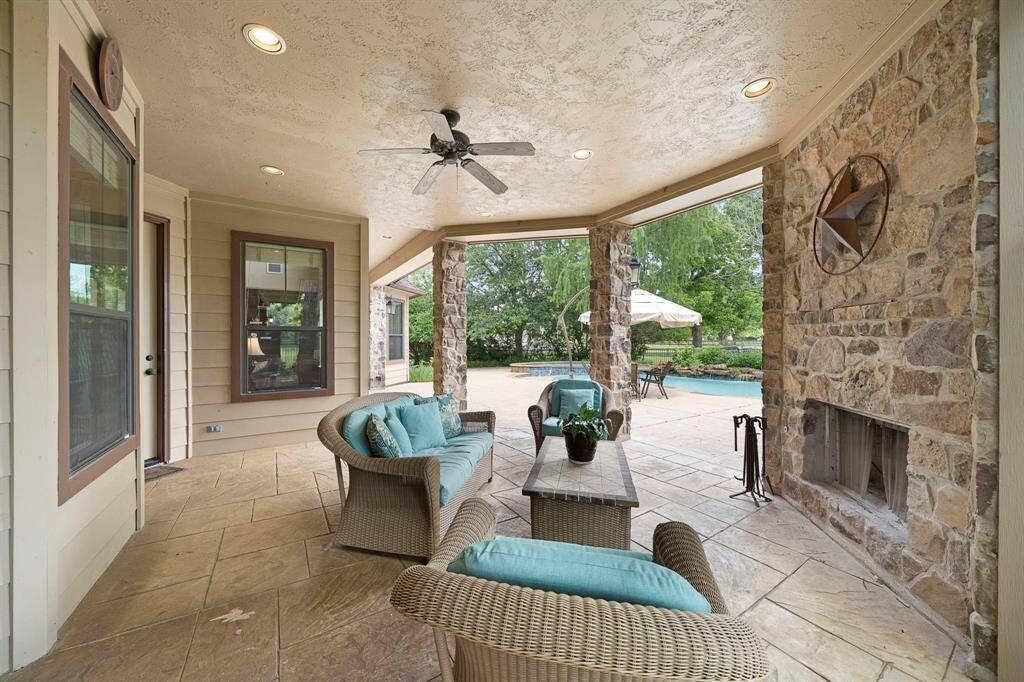 Cozy up by the stone-wrapped wood-burning fireplace on the inviting outdoor patio, perfect for serene evenings.