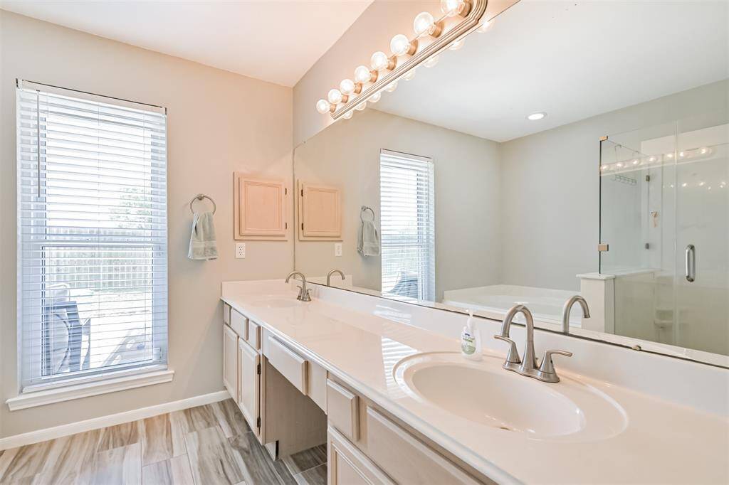 Primary bathroom featuring double sinks, vanity area, and tons of light