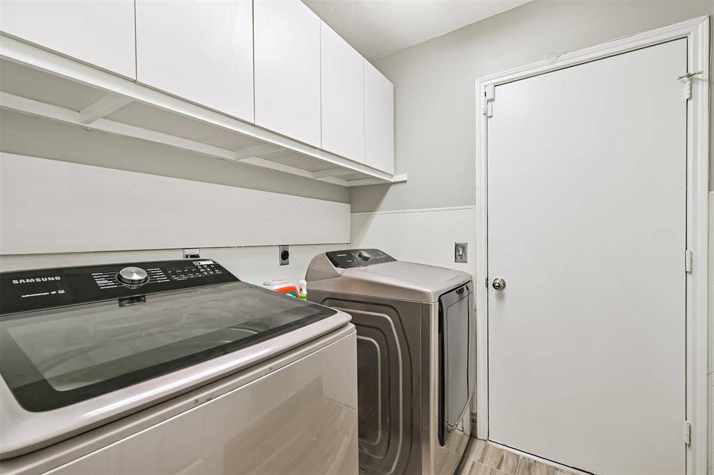 Laundry room with extra cabinet space, storage closet, and garage access