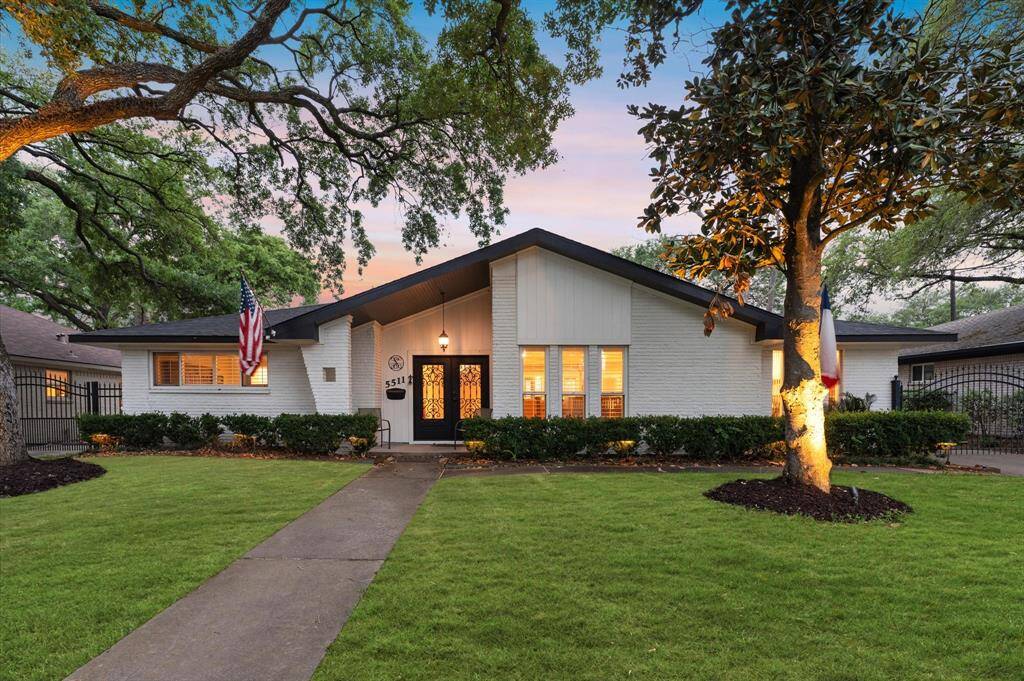 Charming single-story home with a modern façade, featuring a well-maintained lawn and mature trees. The property is accentuated by warm exterior lighting and a welcoming entrance. Ideal for buyers seeking a cozy, stylish residence.