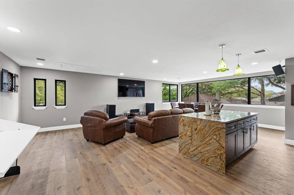 The open layout extends to a cozy seating area, complemented by wood flooring and a built-in Murphy bed.