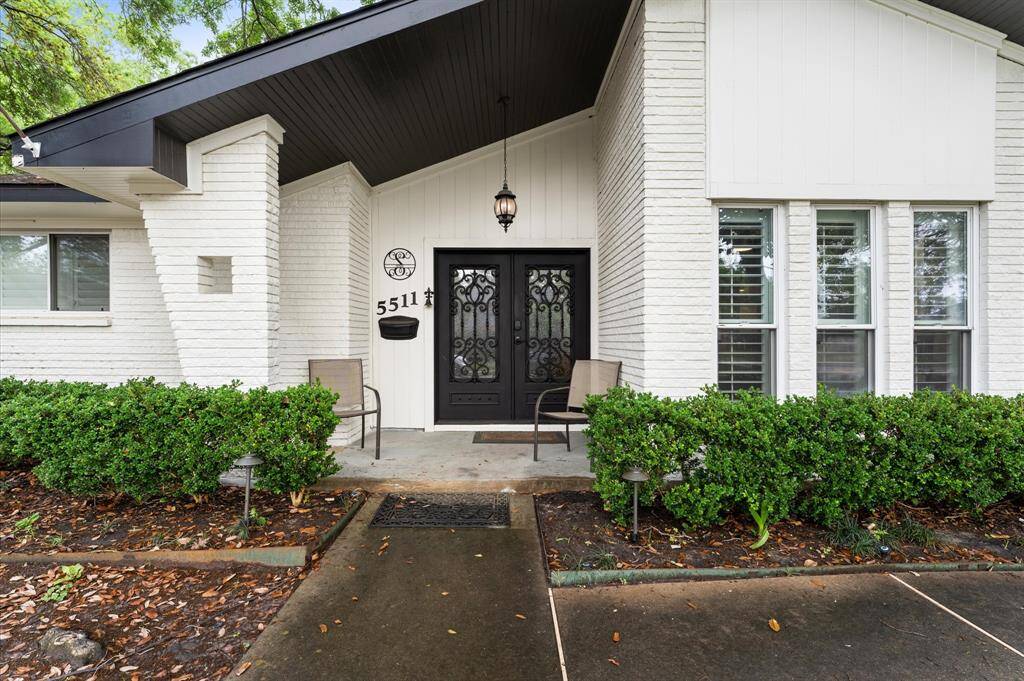 Lovely single-story home with a clean white exterior, nestled among mature trees. Features a manicured lawn, a long driveway, and a welcoming front entrance. Perfect for those seeking a serene residential neighborhood.