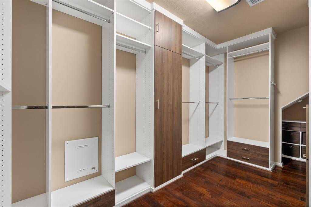 This expansive primary closet is thoughtfully designed with designated spaces for everything: ample hanging and shelf space for clothing, a separate closet just for shoes, and a charming private nook for your treasured jewelry.